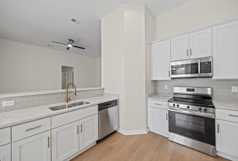 Kitchen with stainless steel appliances and decorative backsplash