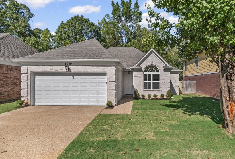 Single story home featuring roof with shingles, concrete driveway, brick siding, and a garage