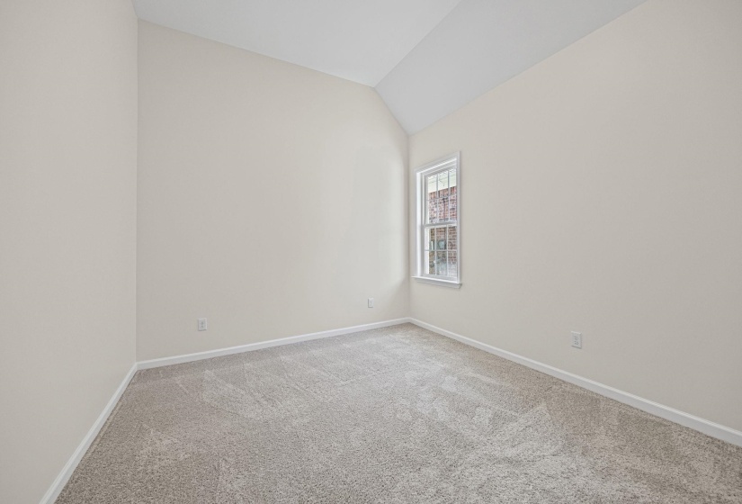 Empty room featuring lofted ceiling and carpet