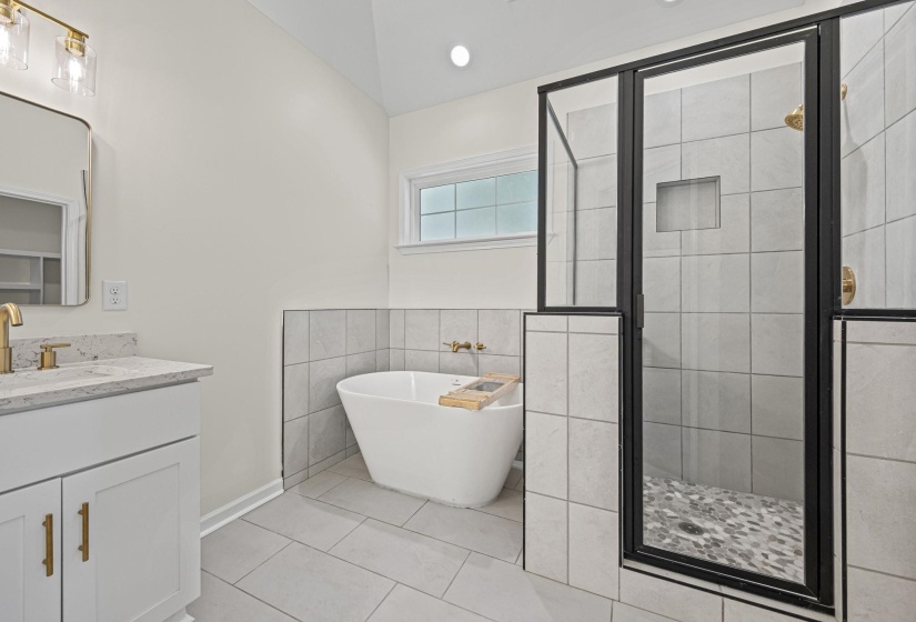 Full bath with vanity, a stall shower, a freestanding tub, tile walls, and recessed lighting