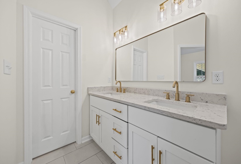 Full bathroom featuring double vanity and light tile patterned flooring