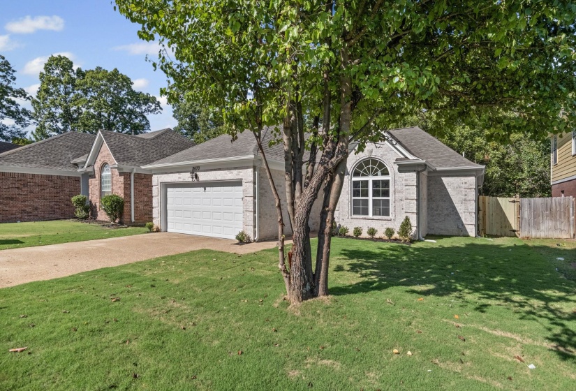 View of front of house with driveway, a garage, brick siding, and roof with shingles
