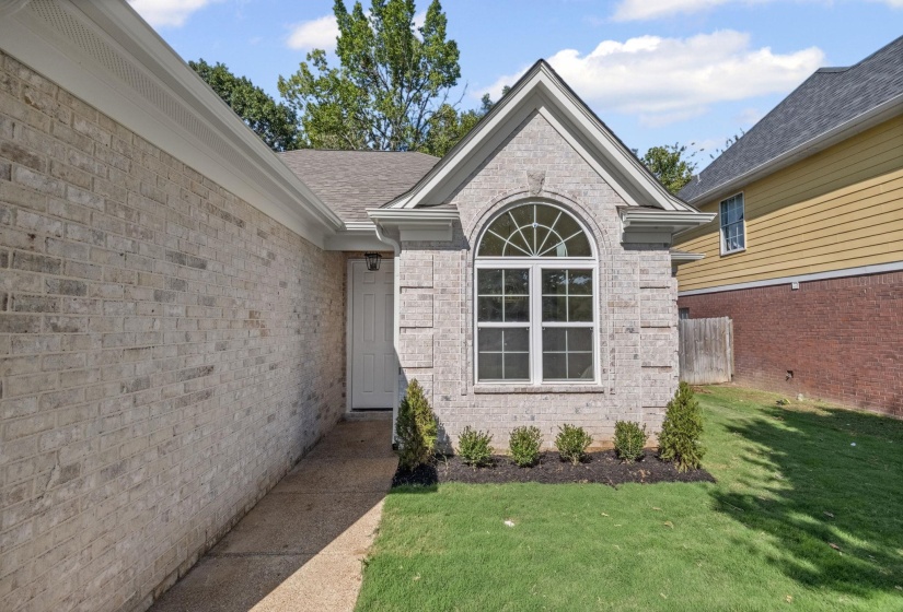 Entrance to property with brick siding and a shingled roof