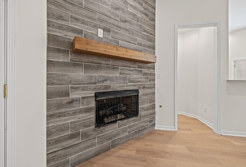 Unfurnished living room featuring wood finished floors and a tile fireplace