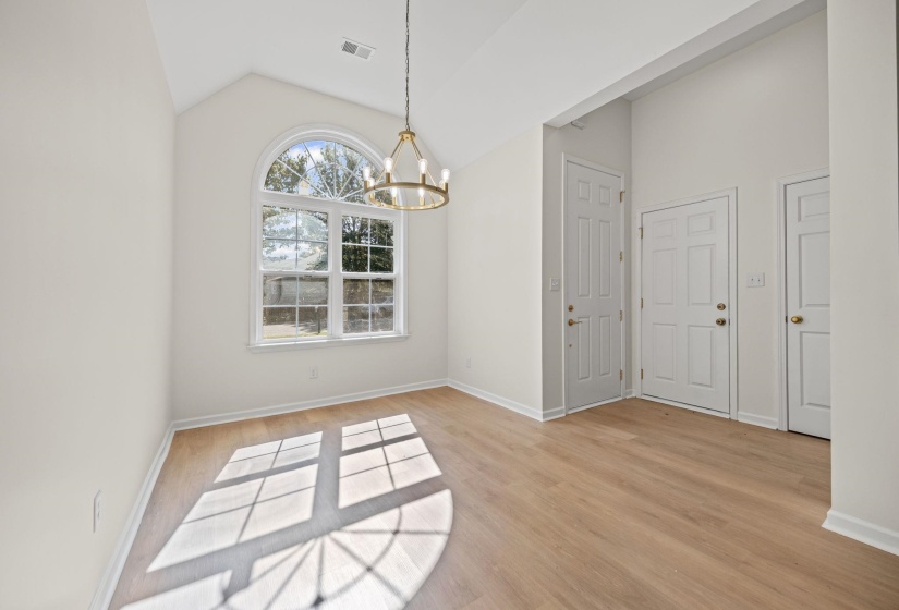 Unfurnished dining area with lofted ceiling, light wood-style floors, and a chandelier