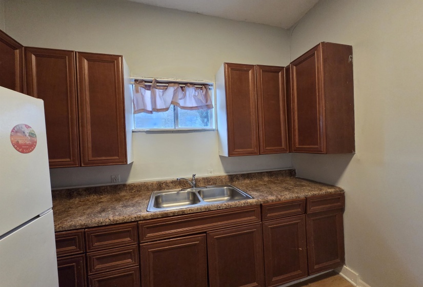 Kitchen with freestanding refrigerator and dark countertops
