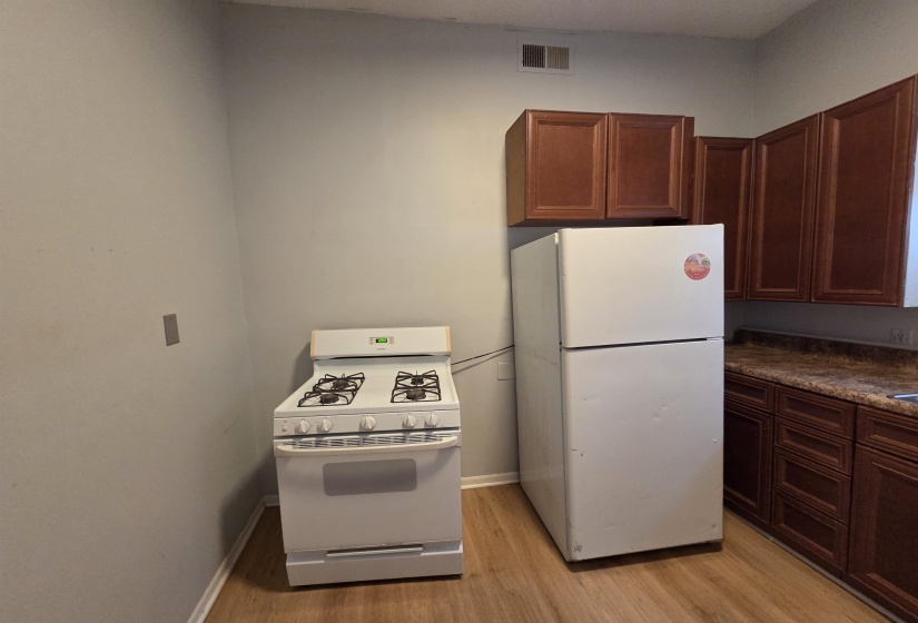 Kitchen featuring white appliances and light wood finished floors