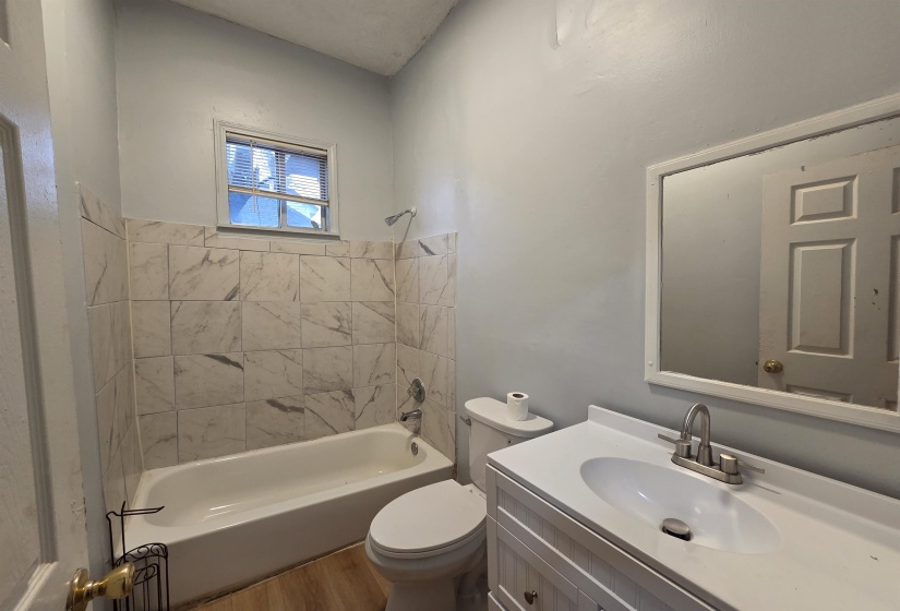 Full bathroom featuring vanity, shower / bathtub combination, and wood finished floors