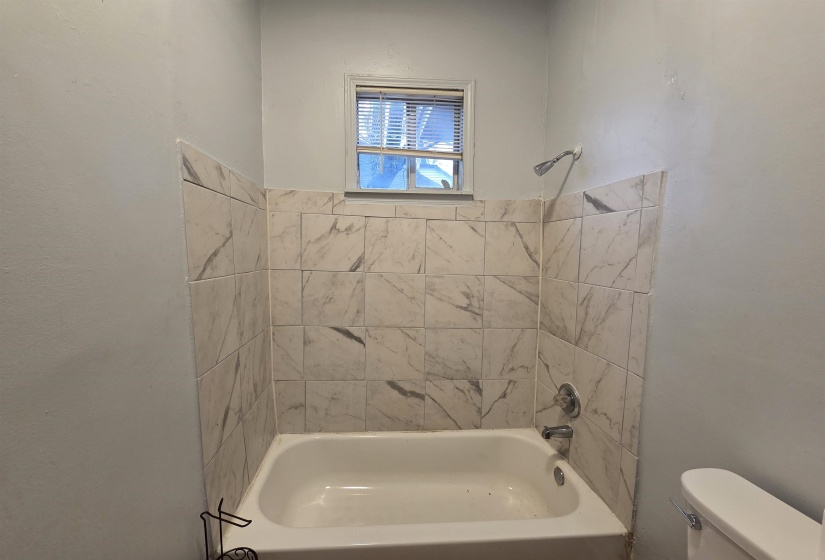 Bathroom featuring toilet and  shower combination