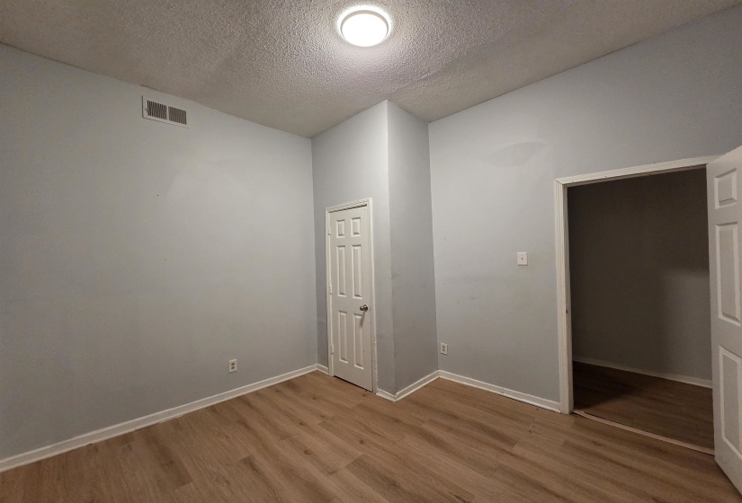 Empty room featuring a textured ceiling and wood finished floors