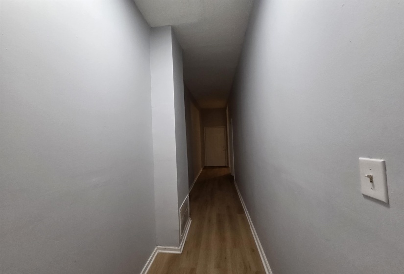 Corridor featuring baseboards and light wood finished floors