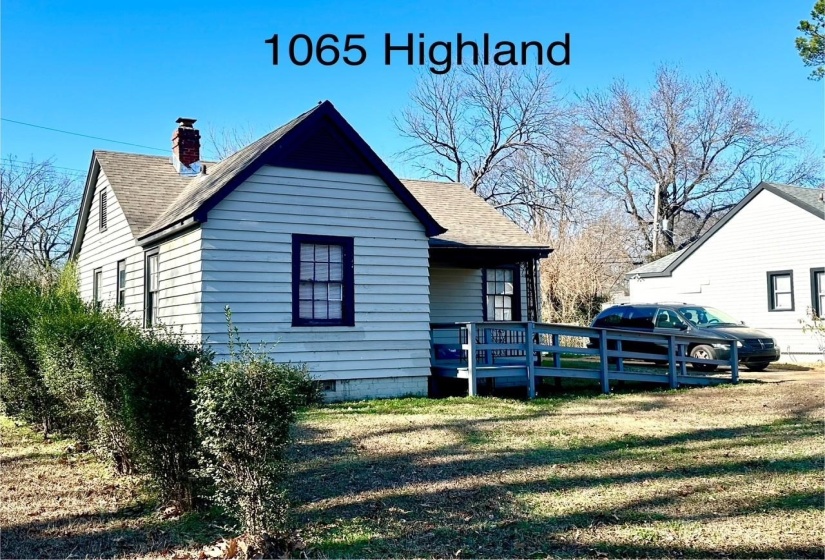 View of side of home featuring roof with shingles, a yard, a chimney, and a wooden deck