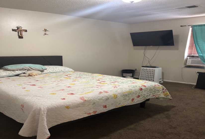 Carpeted bedroom with cooling unit