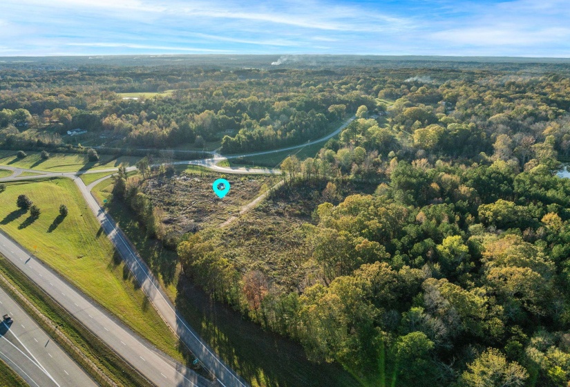 Aerial view of property and surrounding area featuring a heavily wooded area