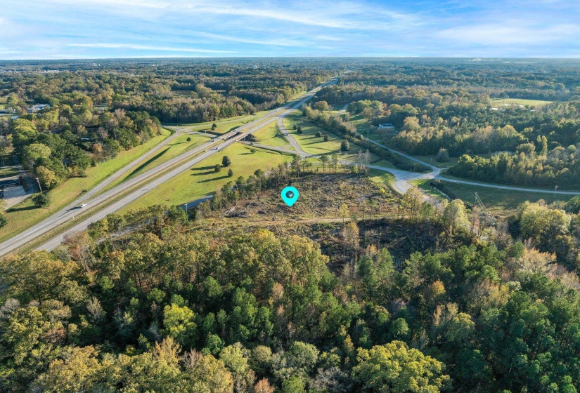Aerial overview of property's location with a heavily wooded area