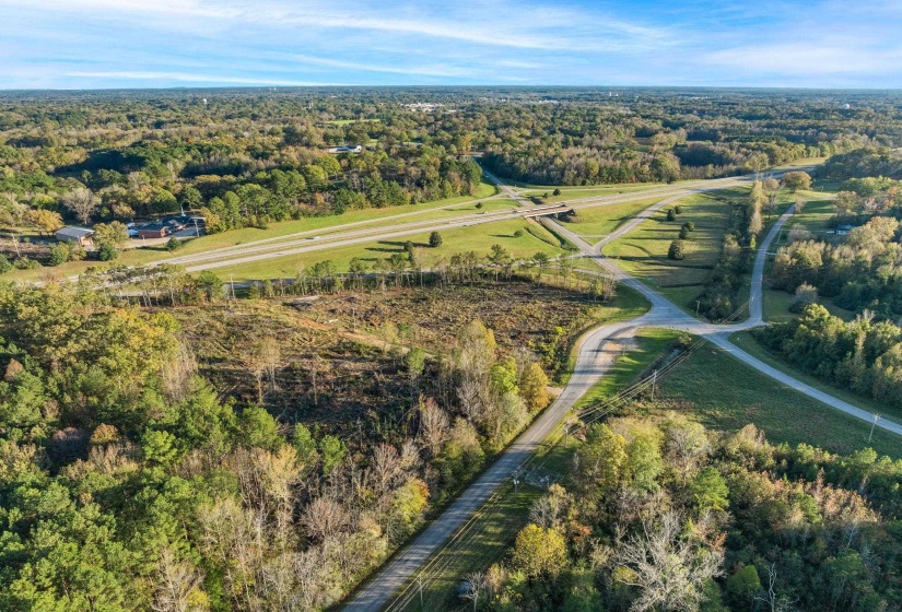 Aerial overview of property's location featuring rural landscape and a heavily wooded area