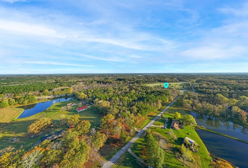 Drone / aerial view of a nearby body of water and a heavily wooded area