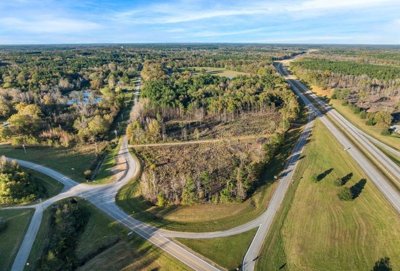Aerial view of property and surrounding area with a heavily wooded area