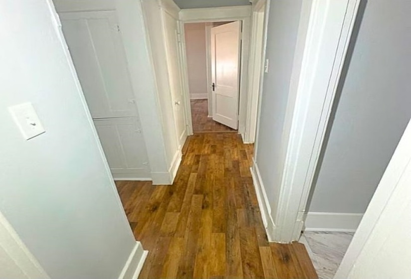 Hall featuring dark wood finished floors and baseboards