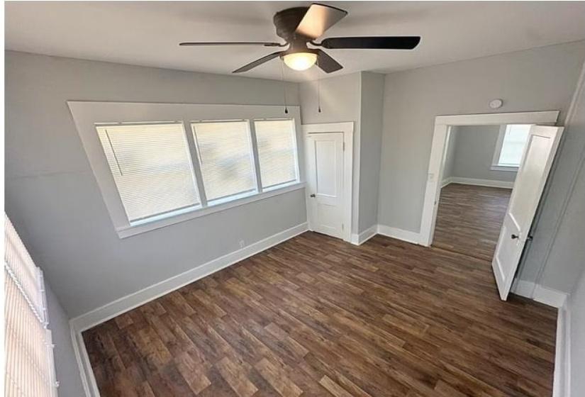 Unfurnished bedroom with dark wood-style flooring and ceiling fan