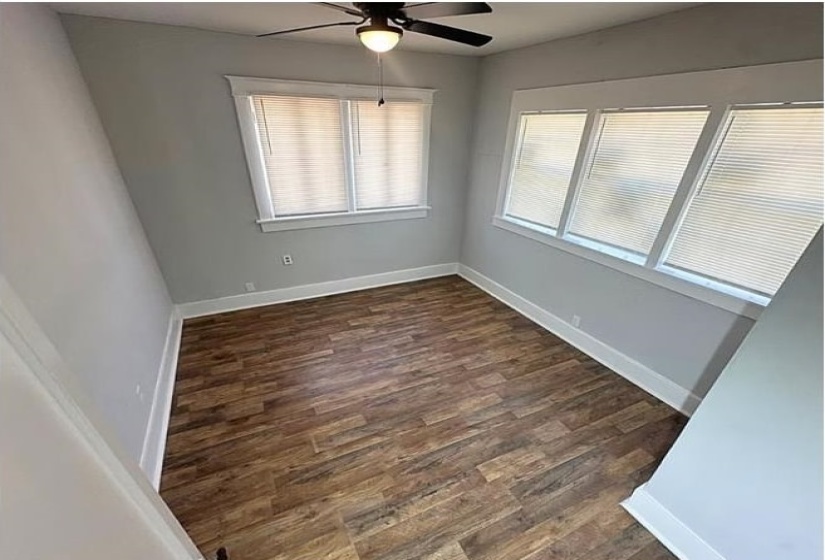 Spare room with dark wood-style floors and a ceiling fan