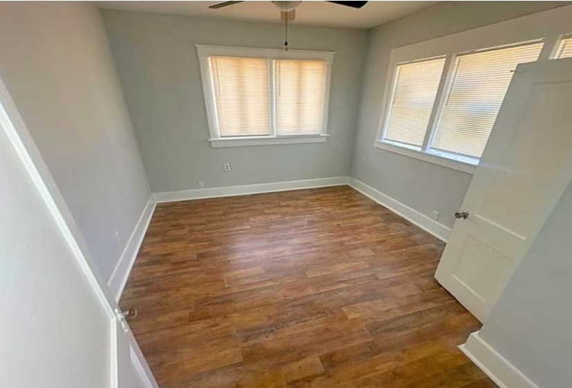Unfurnished room with dark wood-style flooring and ceiling fan