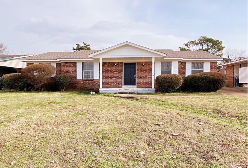 Ranch-style house with a front yard and brick siding