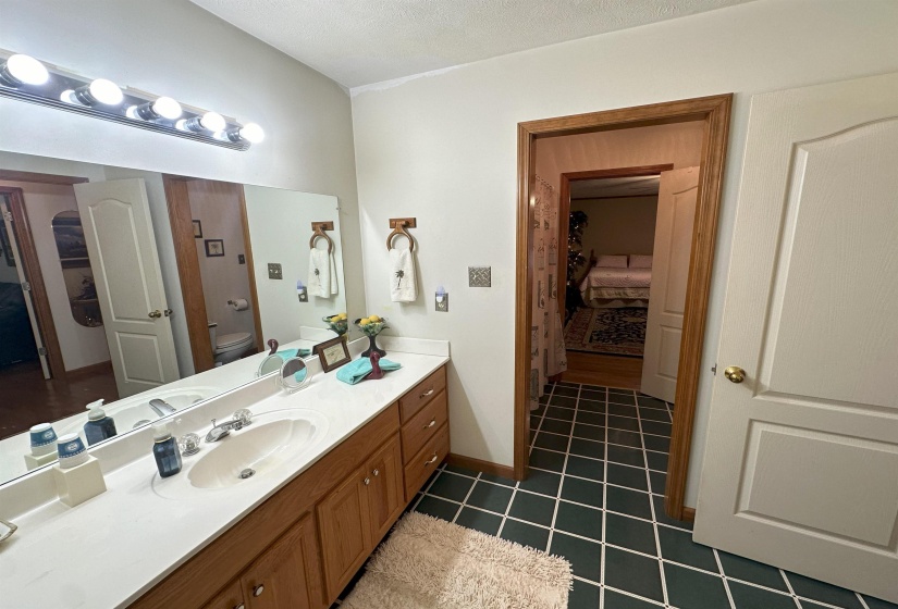 Bathroom featuring toilet, a textured ceiling, vanity, and tile patterned flooring