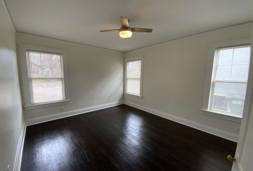 Spare room featuring dark wood-type flooring and a ceiling fan