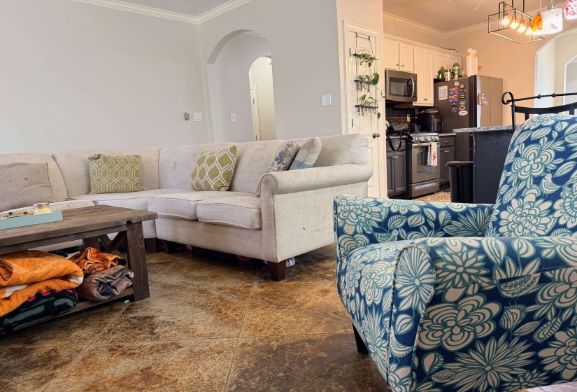 Living area with arched walkways and ornamental molding