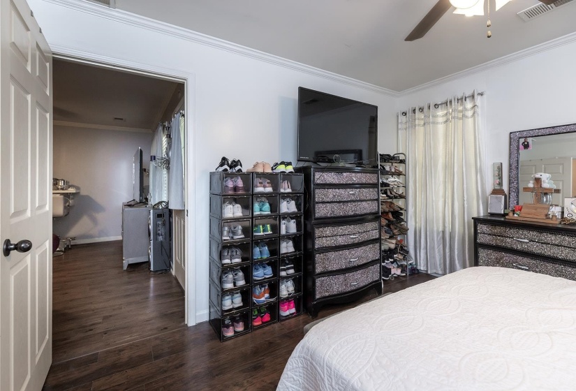 Bedroom with crown molding, dark wood-type flooring, and ceiling fan