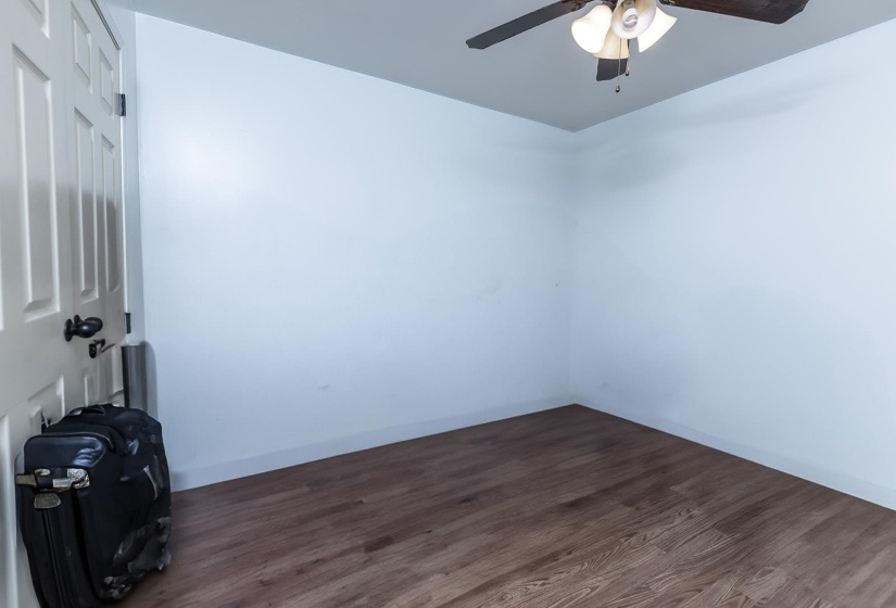 Unfurnished room featuring dark wood-style floors and ceiling fan