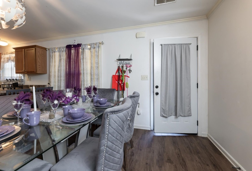 Dining area with crown molding and dark wood-style flooring