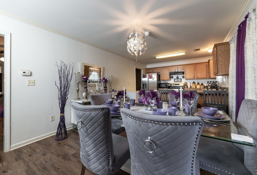 Dining area with ornamental molding, dark wood finished floors, and a chandelier