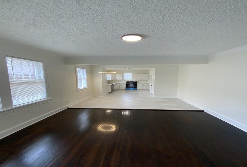 Unfurnished living room with light wood finished floors and a textured ceiling