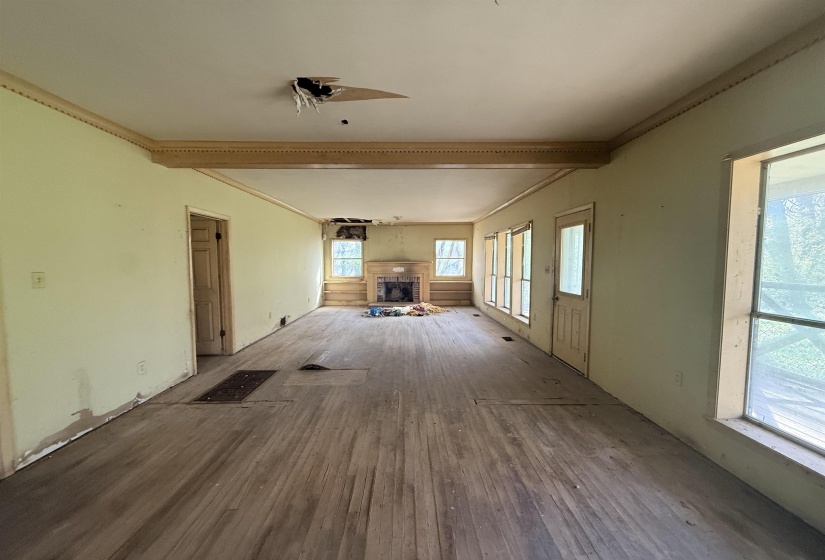Interior space with a fireplace, wood finished floors, and crown molding