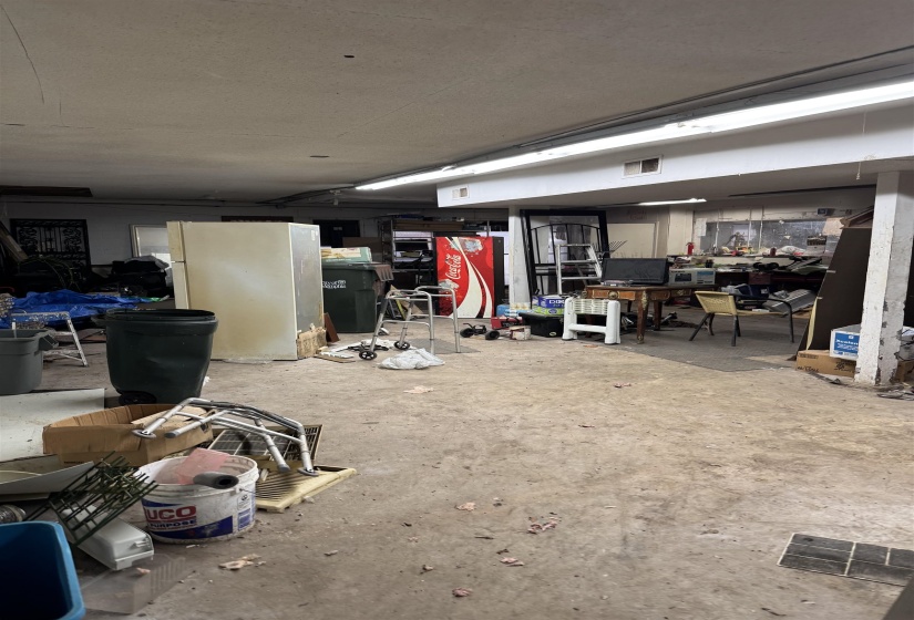 Basement featuring freestanding refrigerator and visible vents