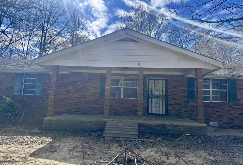 View of front of home with a porch and brick siding