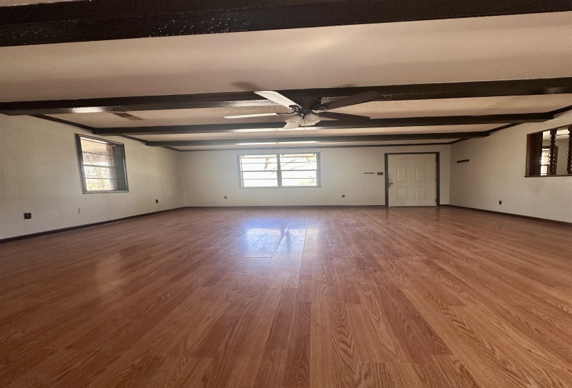 Spare room with beam ceiling and wood finished floors