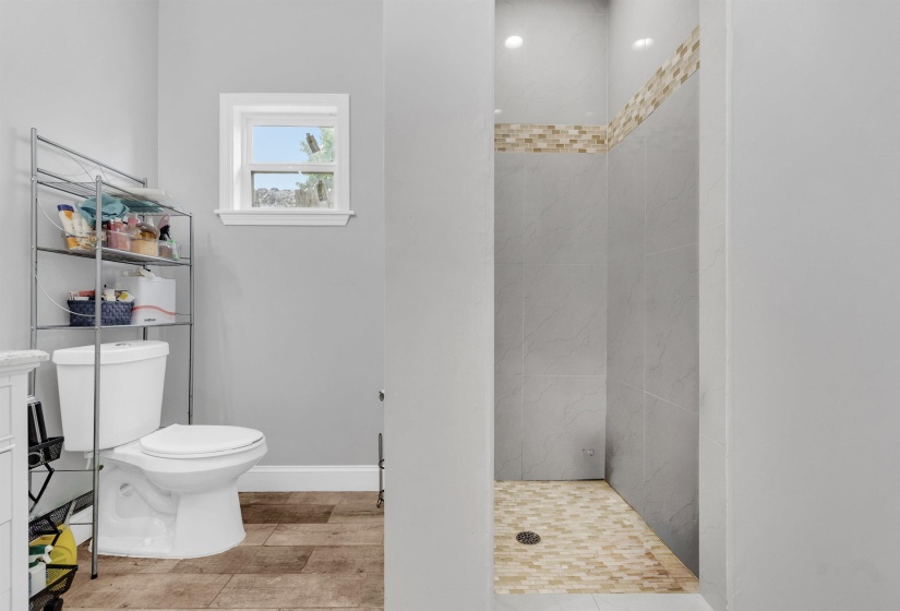 Full bathroom featuring a shower stall and light wood-type flooring
