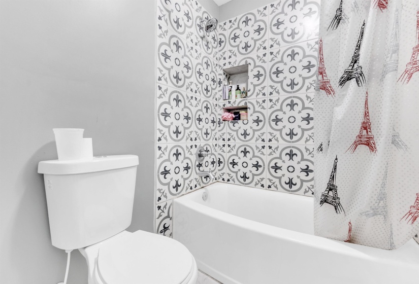 Bathroom with toilet and shower / bathtub combination with curtain
