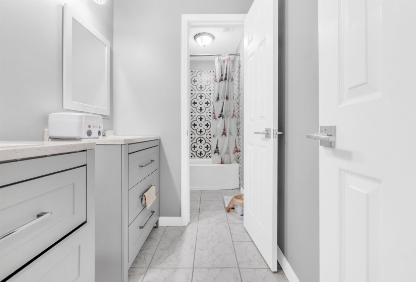 Full bathroom featuring vanity, shower / bath combination with curtain, and light marble finish floors