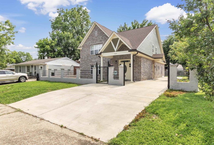 Craftsman house with brick siding, roof with shingles, a gate, and concrete driveway