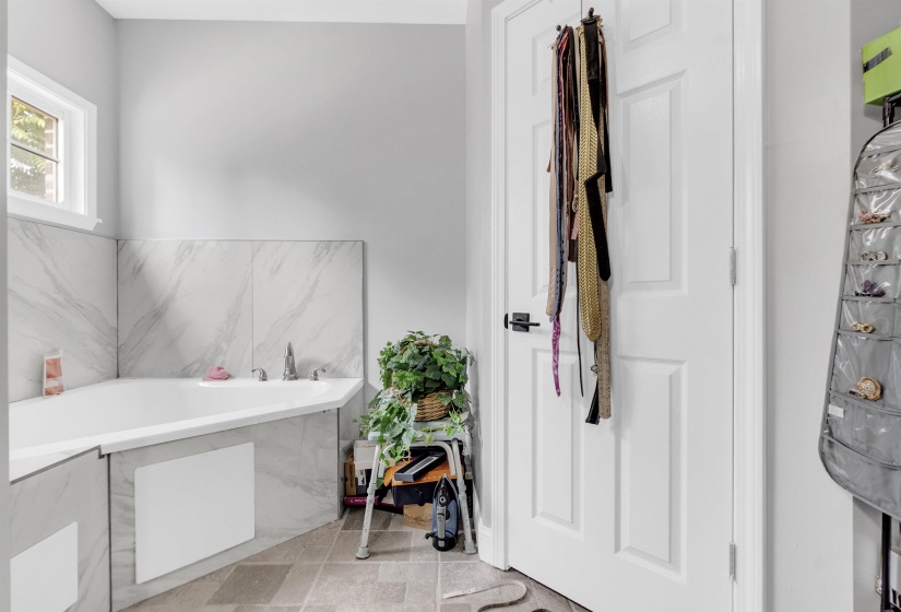 Bathroom featuring a garden tub and light tile patterned flooring