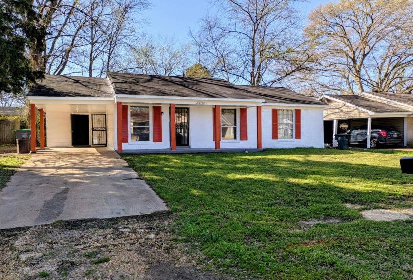 Ranch-style home featuring an attached carport, a porch, concrete driveway, a front yard, and a shingled roof