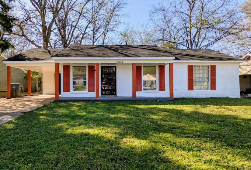 Front of house featuring covered porch, an attached carport, a yard, and driveway