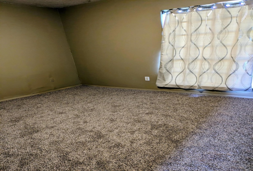 Unfurnished primary bedroom featuring carpet flooring and baseboards