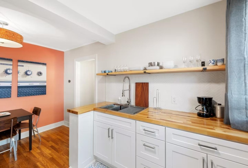 Kitchen with wood counters, white cabinetry, open shelves, light wood-type flooring, and beamed ceiling