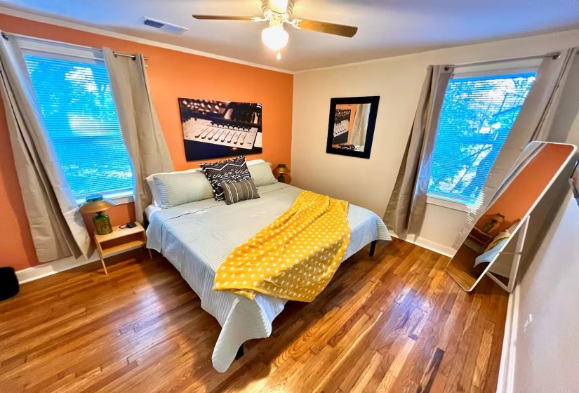 Bedroom featuring wood-type flooring, ceiling fan, and crown molding