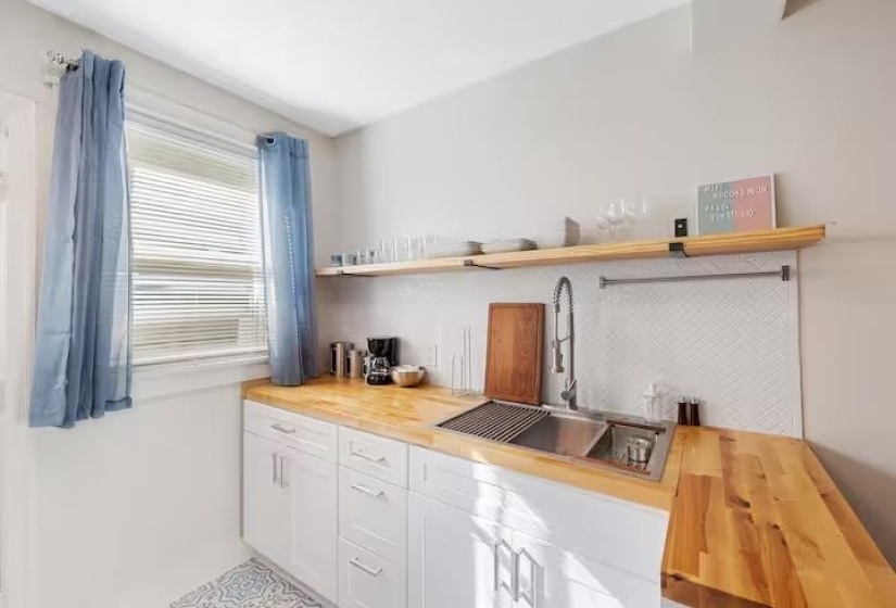 Bar area featuring butcher block counters, white cabinetry, and open shelves
